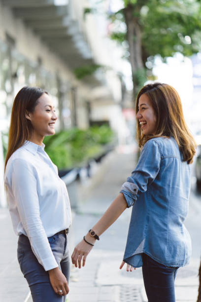 istock Young women holding hands outdoors, cityscape on background 695863414