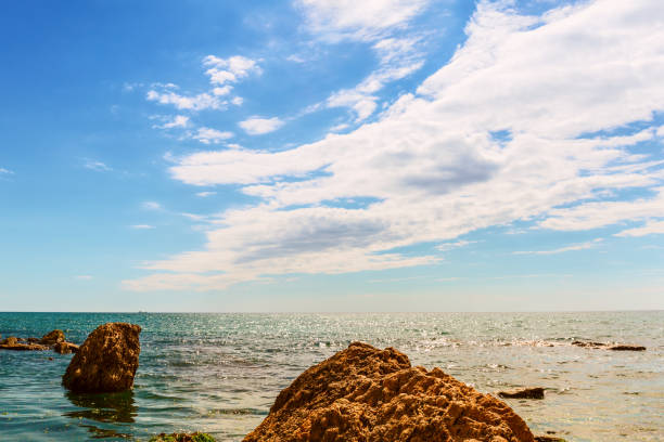istock seascape with stones,sea and sky  with clouds 695873720