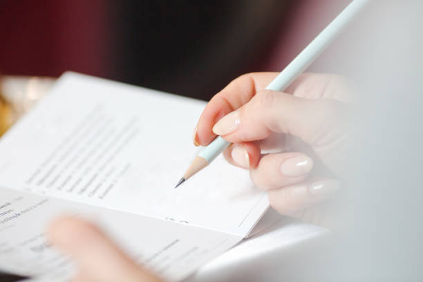 istock woman's hand writing in a booklet entry 695877646