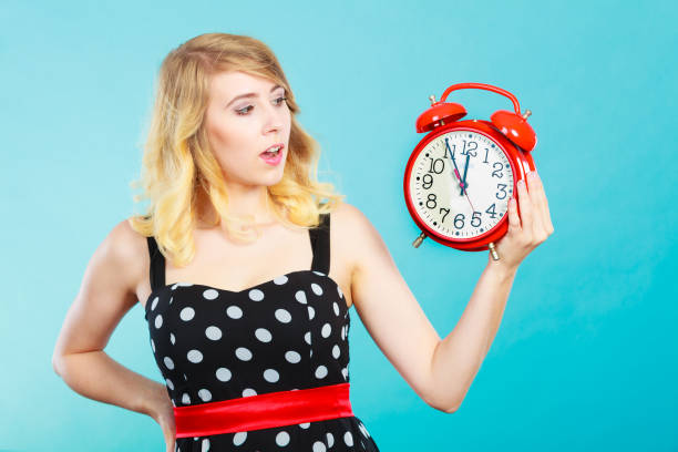 istock Shocked girl with alarm clock on blue. 695877730