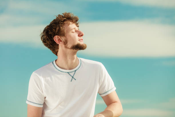 istock Man with closed eyes relaxing breathing fresh air. 695877828