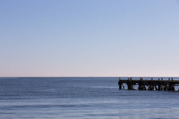 View of a pier with mountains on the background on a misty morning in Canasvieiras, on the city of Florianopolis, in the state of Santa Catarina, Brazil.