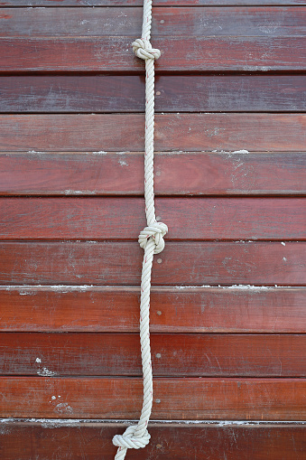White rope tied in a knot and wood plank for adventure.