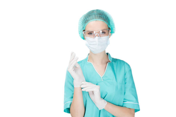 istock surgeon putting on medical gloves and looking at camera isolated on white 695885532