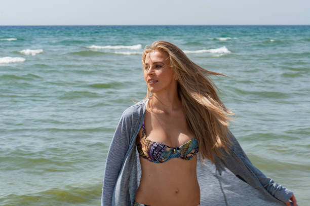 istock Woman walking on the beach 695888598