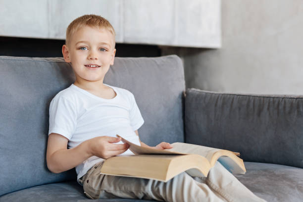 istock Intelligent lively child turning pages of a book 695889112