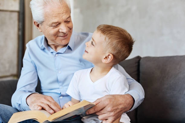 istock Cute energetic kid enjoying time with grandpa 695890264