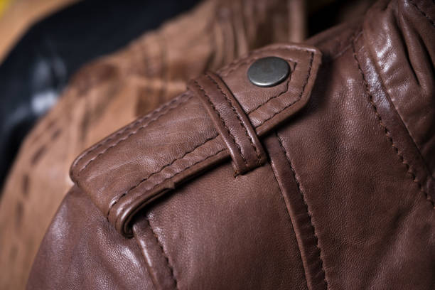istock Brown leather jacket shoulder metal clasp button. Macro leather shoulder detail 695896922