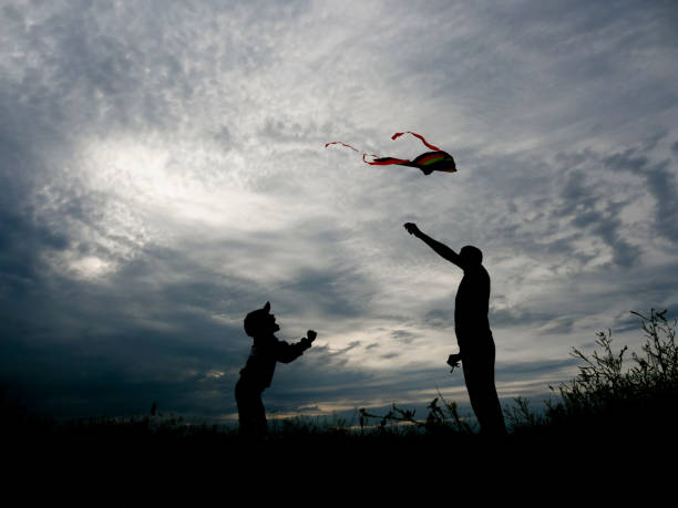 istock happy father and little son launching a kite at sunset 695897122