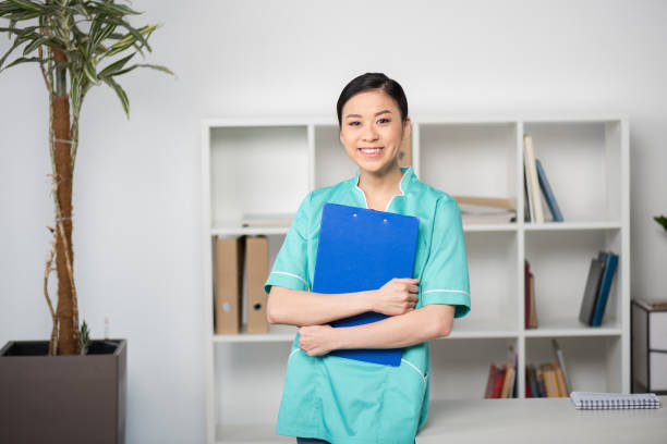 istock smiling asian internist holding clipboard with diagnosis and looking at camera 695897280