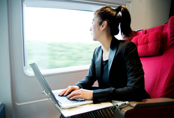 istock Young businesswoman using a laptop on the train 695901072