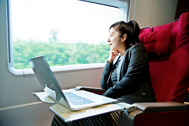 istock Young businesswoman using a laptop on the train 695901216