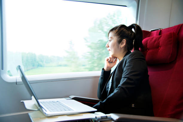 istock Young businesswoman using a laptop on the train 695901274