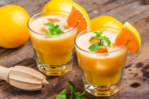 istock Fresh orange juice, mint and ice on dark background, top view 695901424