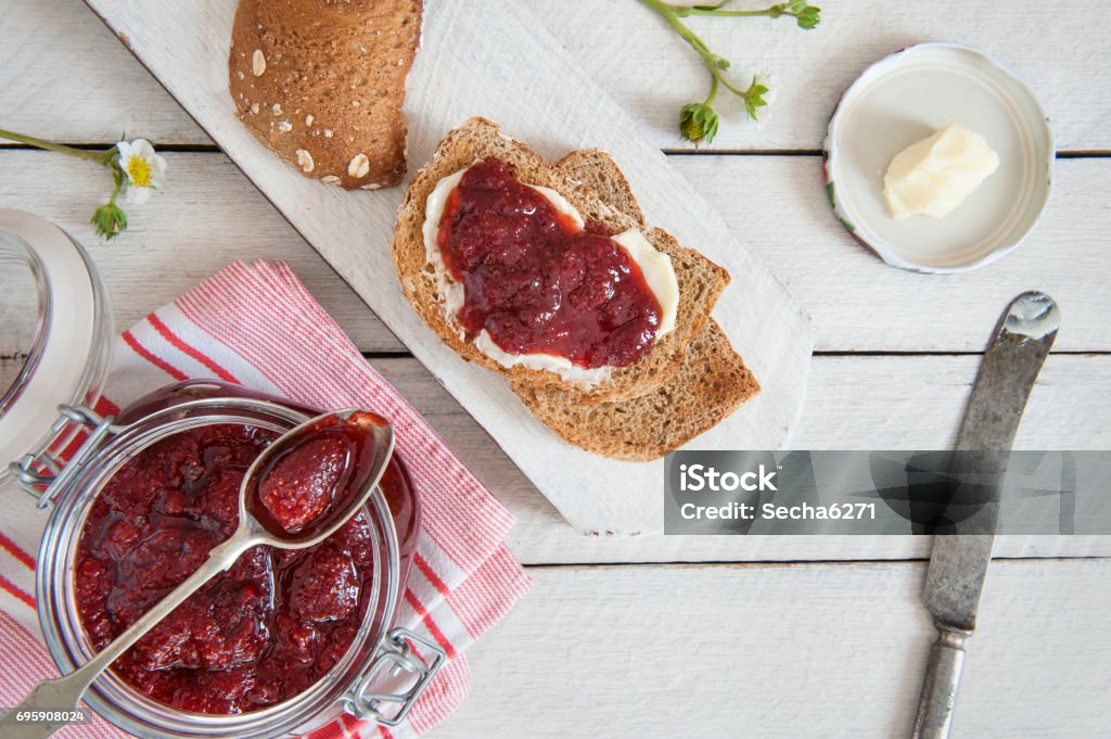 Strawberry jam and bread Homemade  strawberry jam on a rustic wooden table Preserves Stock Photo