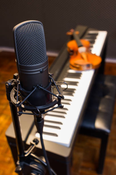 istock condenser microphone on piano & violin background 695909458