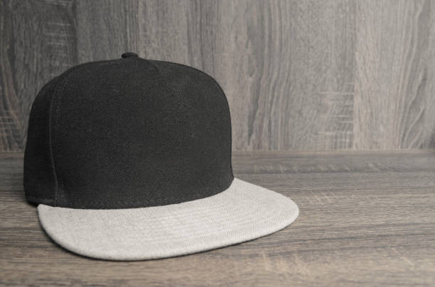 istock Black cap with light gray flap on a wooden background 695909780