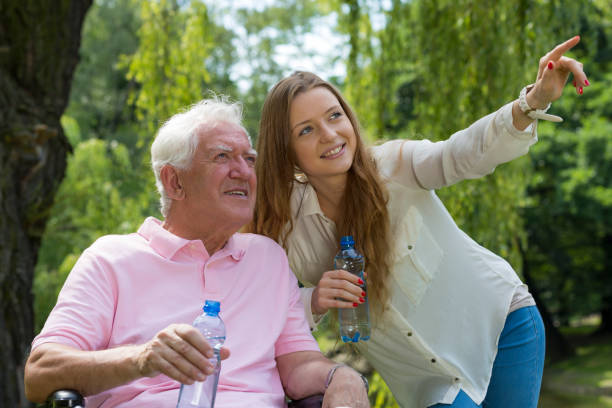 Young female carer with senior man Young female carer pointing something with her finger to the senior man united states senate committee on health education labor and pensions stock pictures, royalty-free photos & images