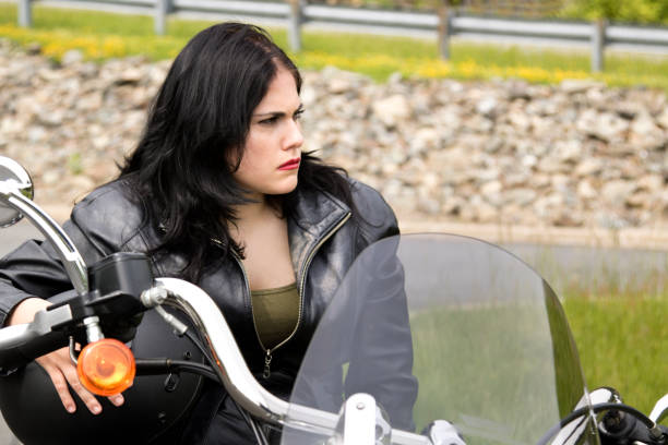 istock Biker Chick sitting on a motorcycle looking to left with a tough stare 695914946