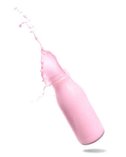 Strawberry milk splash out of bottle isolated on white background.