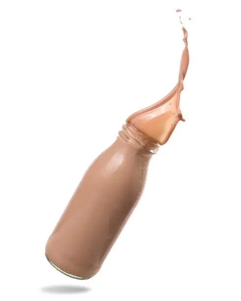 Chocolate milk splash out of bottle., Isolated on white background.