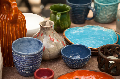 Lots of handmade tableware - ceramic cups, plates at pottery shop