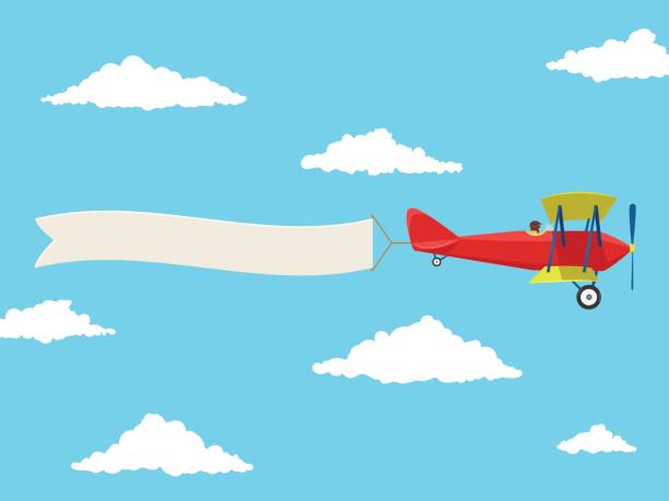 istock Red airplane with pilot and advertising banner in the cloudy sky 695916586