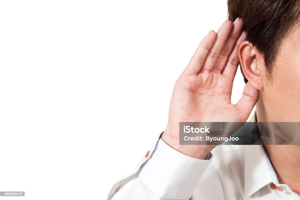 empresario mantener su mano junto a la oreja para escuchar cuidadosamente, aislado en fondo blanco - Foto de stock de Escuchar libre de derechos