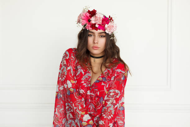 istock Young woman with red flowers wreath 695921134