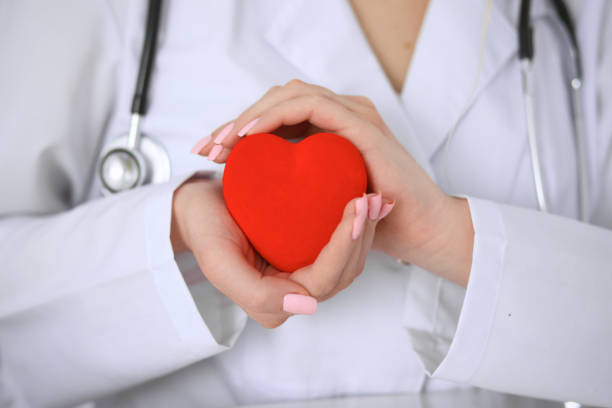 istock Female doctor with stethoscope holding heart. 695923550