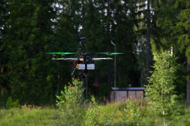 istock Drone with green props is flying in a bright summer day. Forest as a background. 695939634