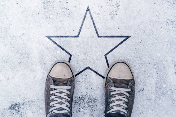 istock Sneakers on the road with star shape imprint 695939774