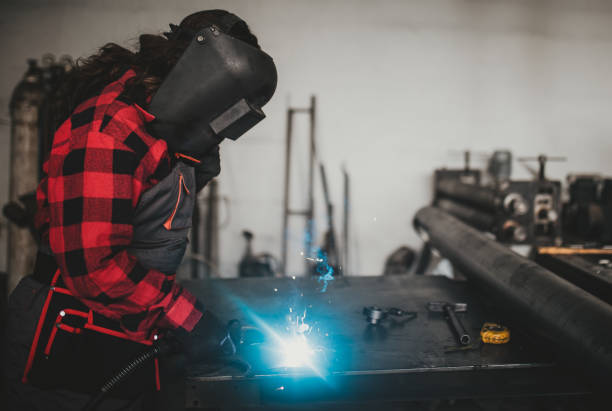 istock Young woman welding in workshop 695943508