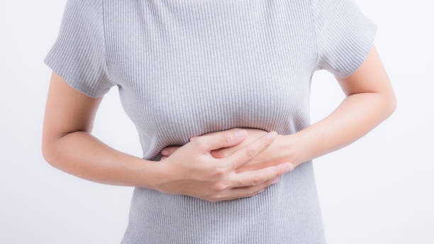 istock Asian women with abdominal pain on white background 695946770