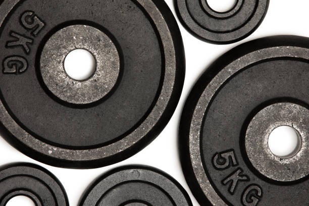 istock Close-up view of different weight plates for weight training isolated on white 695947042