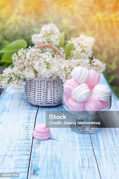 White And Pink Marshmallows In Round Glass Vase With A Basket Of Delicate White Lilac The Horizontal Frame Stock Photo - Download Image Now