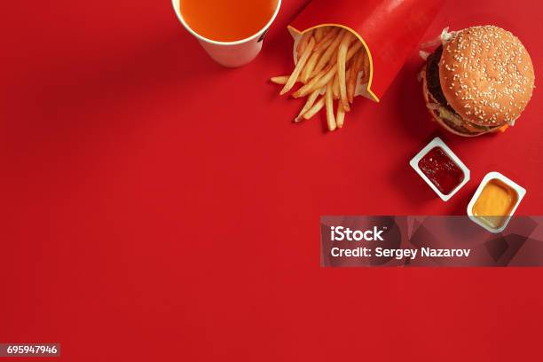 Fast Food Dish Top View Meat Burger Potato Chips And Glass Of Drink On Red Background Takeaway Composition Stock Photo - Download Image Now