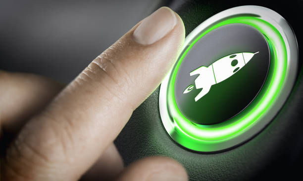 Career Accelerator, Boost Button Man finger pressing an boost button with a rocket icon, black background and green light. Composite between a photography and a 3D background. Start-up concept. kick off stock pictures, royalty-free photos & images