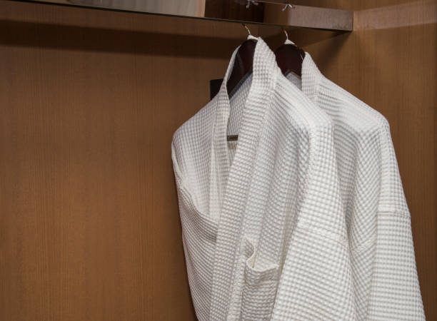 istock White bathrobes with wooden hangers 695948958