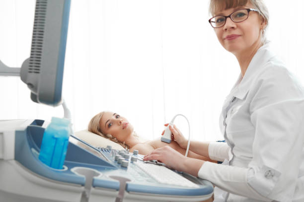 young woman getting breast ultrasound scanning - ultrasound imagens e fotografias de stock