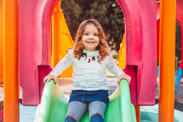 istock Happy little girl having fun with sliding 695958424