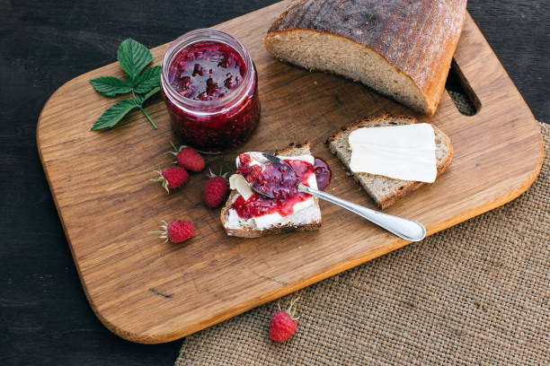 istock Raspberry jam and bread with butter in a jar on the wooden table Lunch breakfast 695971042