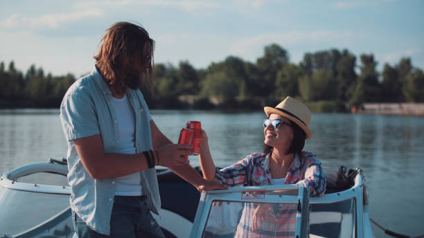 young couple toasting each other in a motorboat - speedboat leisure activity relaxation recreational boat imagens e fotografias de stock