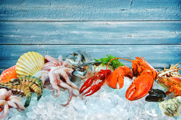 Fresh seafood on crushed ice Fresh fish and seafood arrangement on crushed ice catch of fish photos stock pictures, royalty-free photos & images