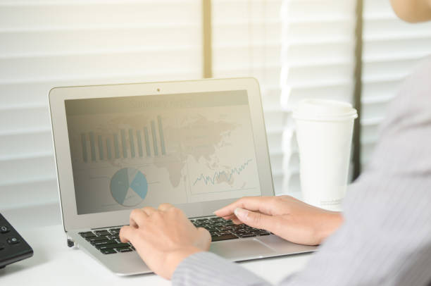 istock Close up business woman working in office with business graph on computer 695985734