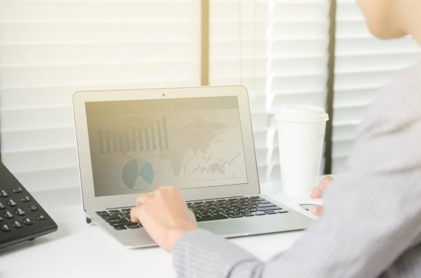 istock Close up business woman working in office with business graph on computer 695985736