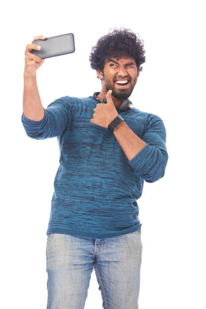 istock Cheerful young man taking selfie with latest smart phone 695987650