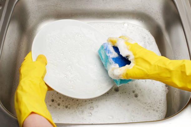 istock Hands in  gloves washing plate with blue cleaning sponge 695988066