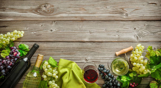 istock Wine bottles with grapes and corks on wooden background 695995444