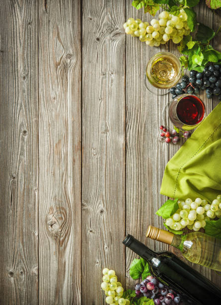 istock Wine bottles with grapes and corks on wooden background 695995452